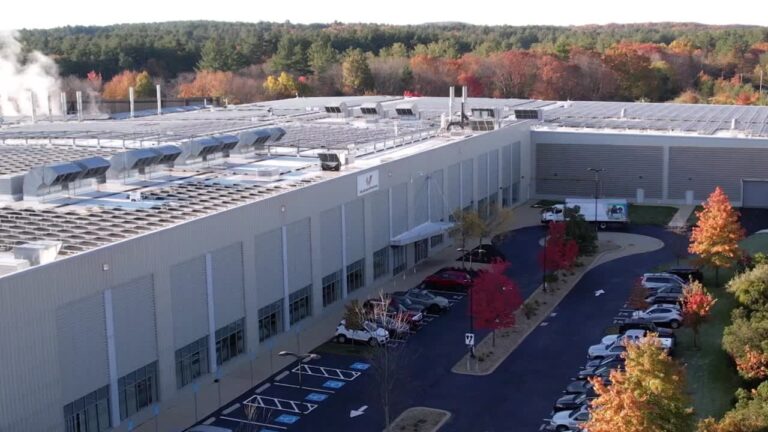 Modern facility with solar panels and autumn foliage, showcasing the company's commitment to sustainability and innovation.