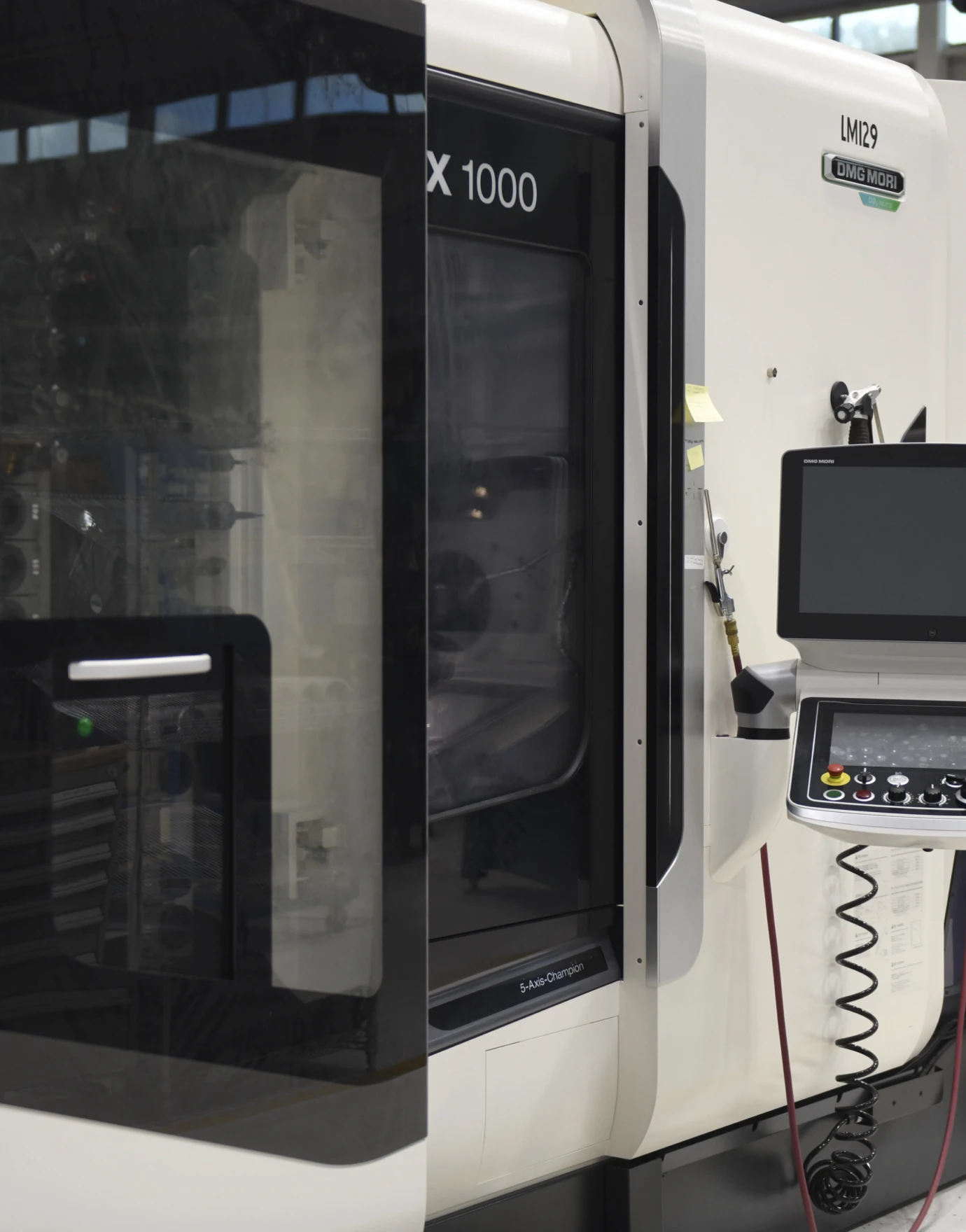 Advanced CNC machine with a transparent door and control panel, showcasing precision manufacturing capabilities.