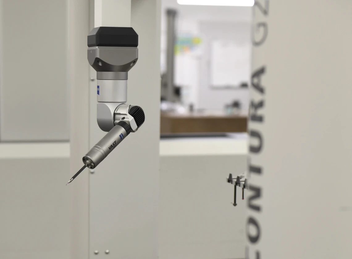 A precision measurement probe attached to a machine in a laboratory setting, designed for quality control and analysis.